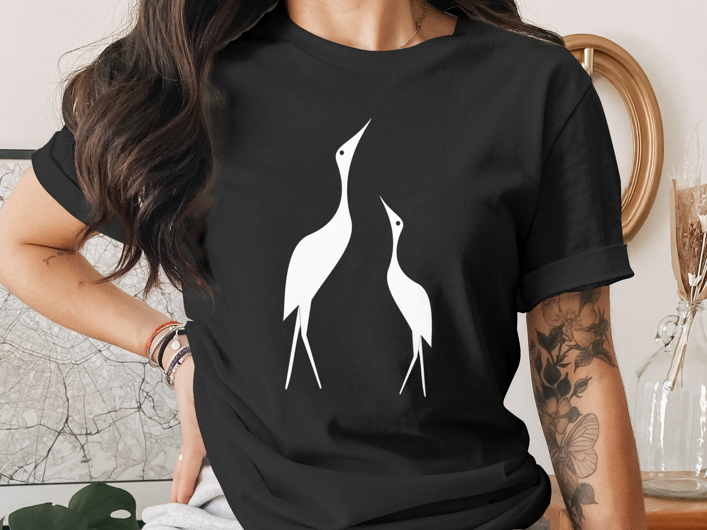 Black t-shirt with a minimalist white graphic of two cranes looking up.