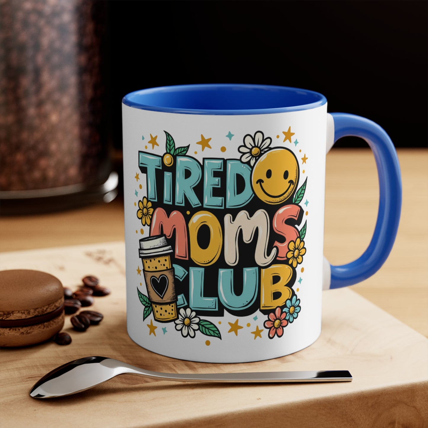 Mug with "TIRED MOMS CLUB" text, smiley face, and flowers.