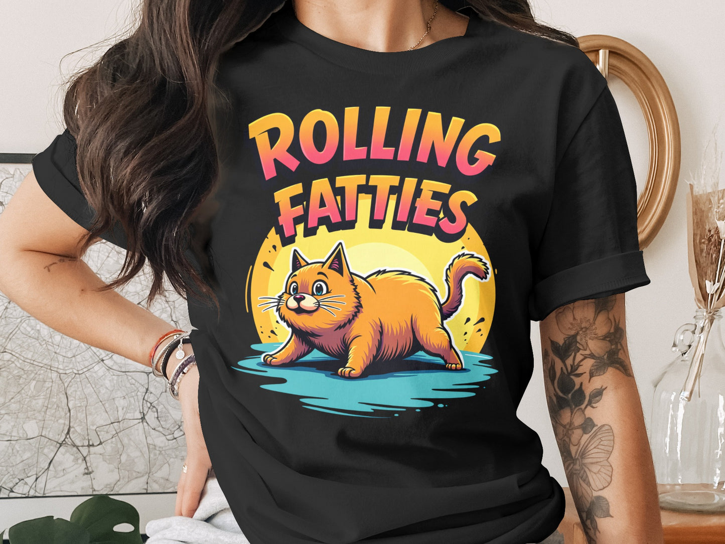 Orange cat with text "ROLLING FATTIES" on a black t-shirt.