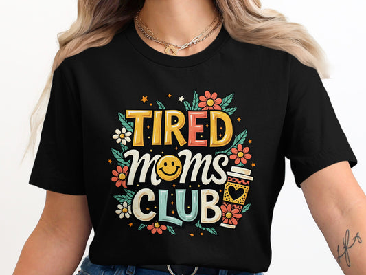Black t-shirt with "Tired Moms Club" text, smiling face, and coffee cup.