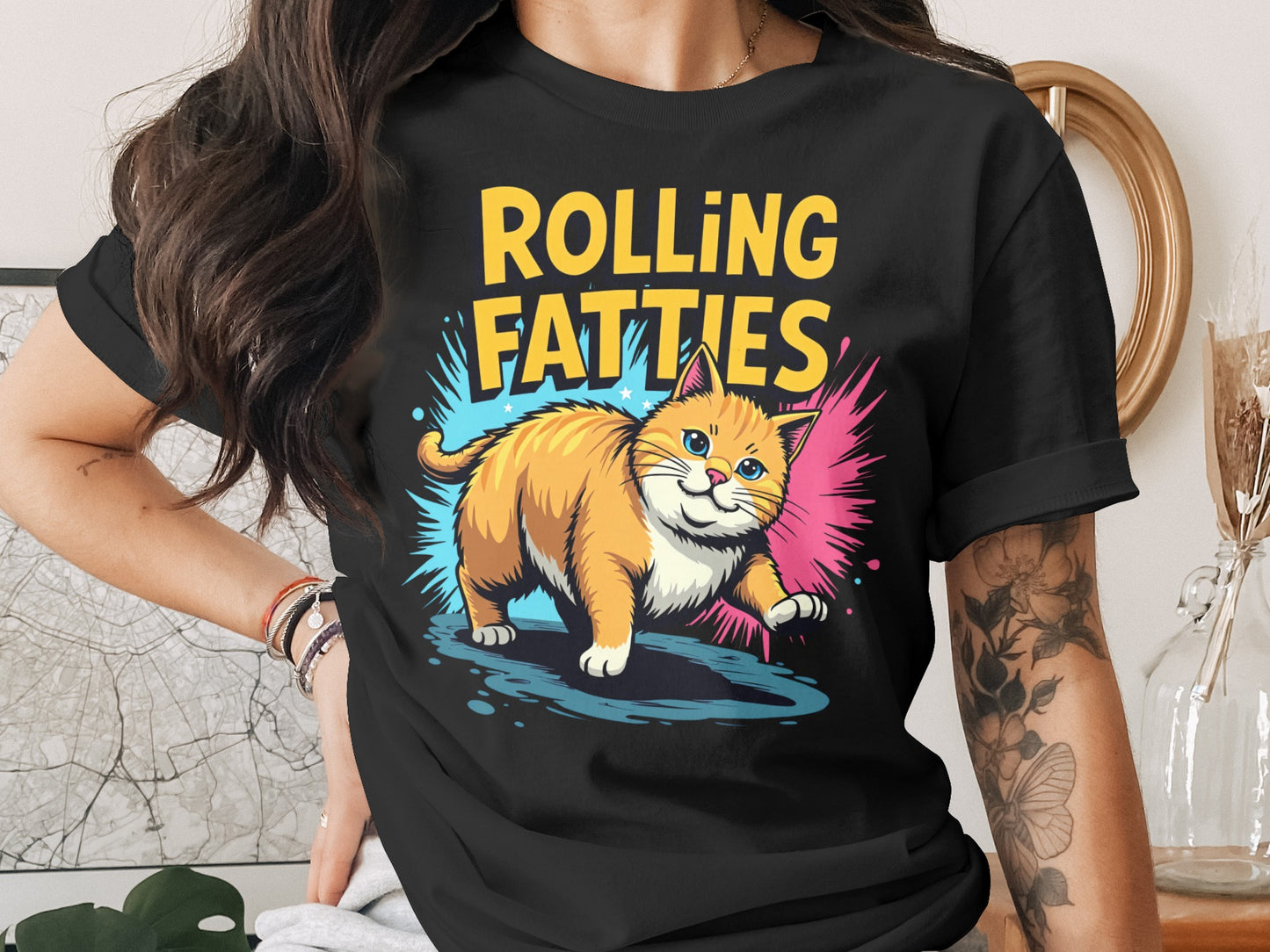 Orange cartoon cat with text "ROLLING FATTIES" on a black t-shirt.