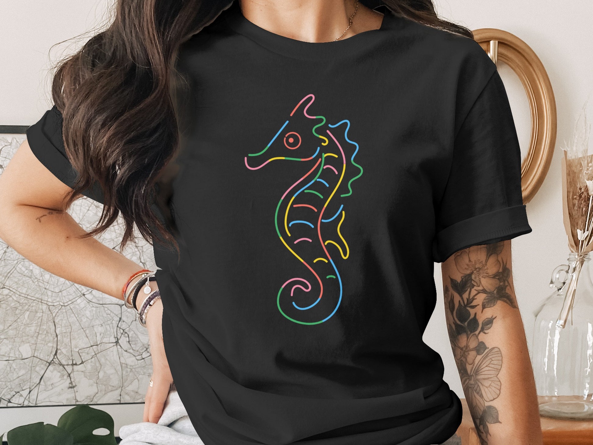 Black t-shirt with a colorful outline seahorse graphic across the chest.